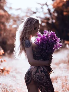 tattooed blonde with flowers on a hot summer day