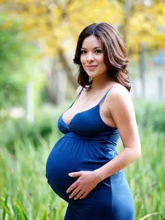 beautiful busty pregnant brunette in a blue dress