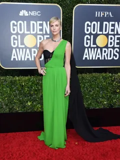 charlize theron in a sexy green and black dress photographed arriving at the golden globe awards.