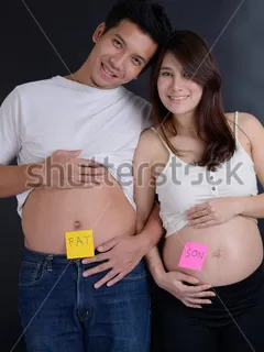 belly of asian pregnant wife and husband with funny inscription